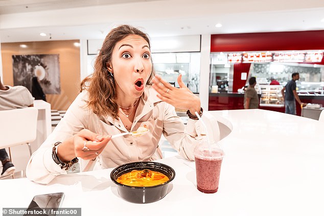 A woman eating spicy food. Scientists say you can train yourself to tolerate spicy food and possibly even get a kick out of it (stock image)