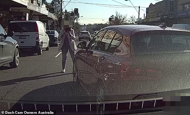 The woman (pictured) got out of the BMW and began taking pictures of the male driver after she hit the other car while attempting to overtake the vehicle