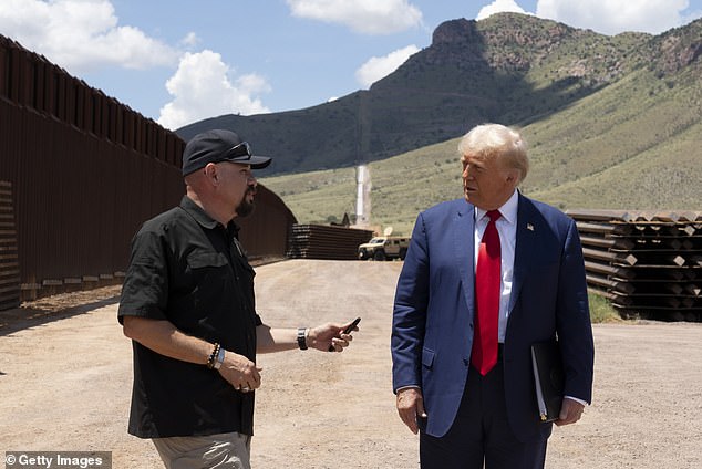 Art Del Cueto, a board member of the National Border Patrol Council, walks with Republican presidential candidate and former President Donald Trump along the U.S.-Mexico border on August 22, 2024, south of Sierra Vista, Arizona. Del Cueto told DailyMail.com that the White House has been playing with the number of official migrant crossings