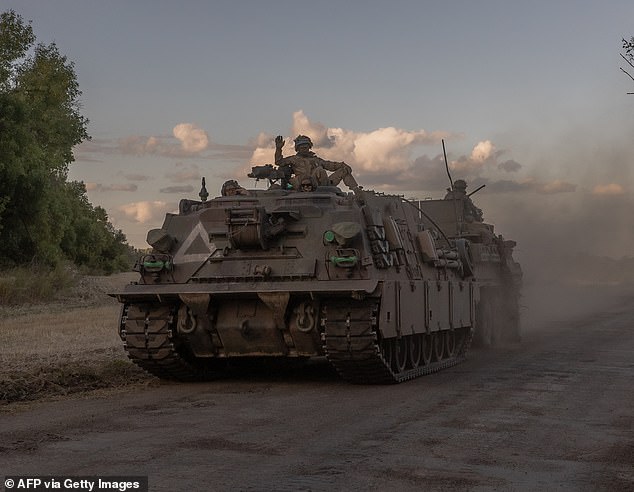 Ukrainian soldiers drive an armored military vehicle in the Sumy region, near the border with Russia, on August 12, 2024