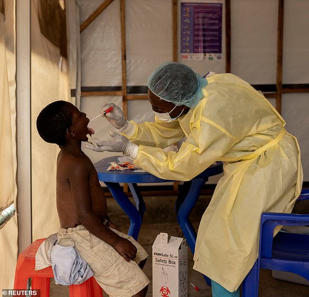 Christian Musema, a laboratory nurse, takes a sample from a child who has been diagnosed as a suspected case of Mpox