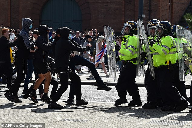 Police officers face protesters outside the Royal Liver Building in Liverpool on August 3 during the 'Enough is Enough' demonstration