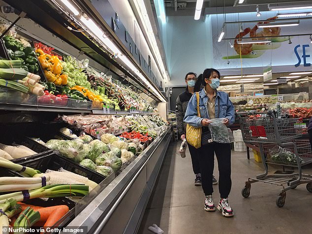 People wearing face masks to protect themselves from the coronavirus at a grocery store on March 27, 2020 in Markham, Ontario, Canada