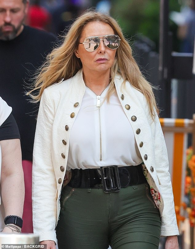 The outspoken radio presenter showed off her ageless figure with an oversized black belt and a cream military jacket that she wore over a tight white top