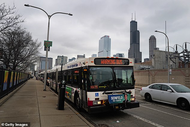 Buses used to warm up migrants are parked in front of the 