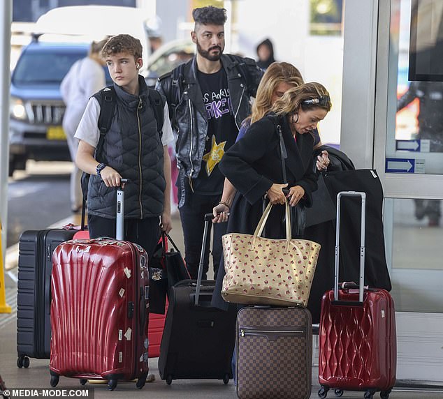 The pop star, 52, rocked her best angles in a black overcoat paired with matching knee-high boots. Pictured with her son Ethan and boyfriend Adrian Newman