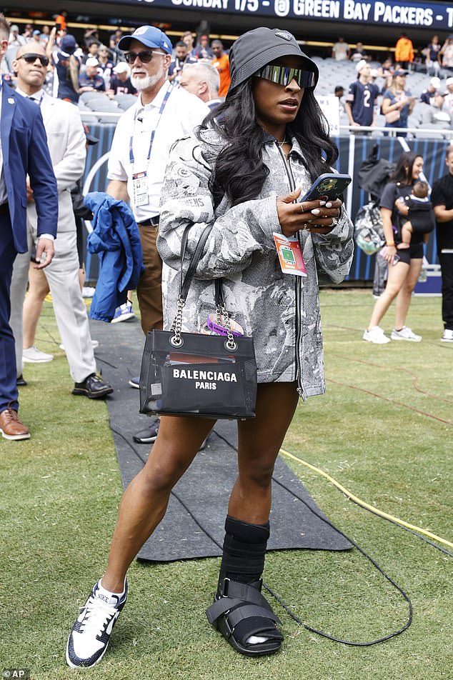 As she walked along the sideline, Biles also wore a protective boot on her left foot