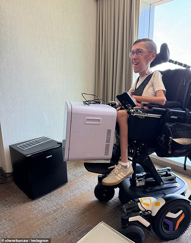 Shane is pictured in his motorized wheelchair