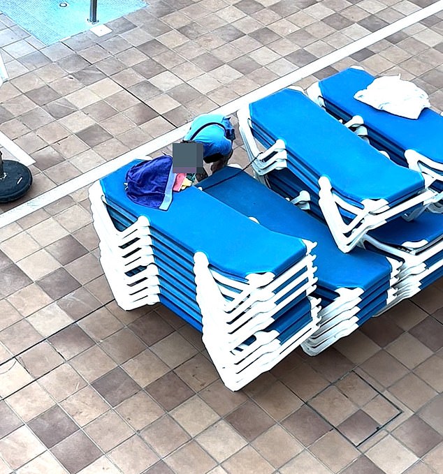 A man appears to be removing secured sunbeds in an attempt to get the best spot by the pool