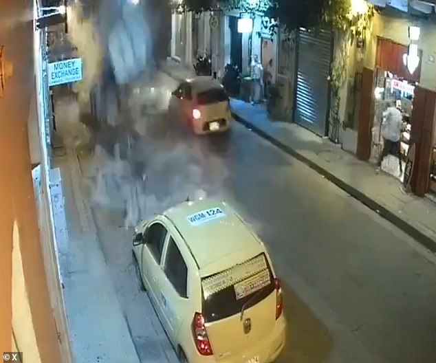 A taxi driver (above) narrowly avoided being crushed to death after a second-story balcony of a vacant building collapsed in Cartagena, Colombia, on Thursday. No injuries were reported and three cars, including the two taxis pictured, were damaged