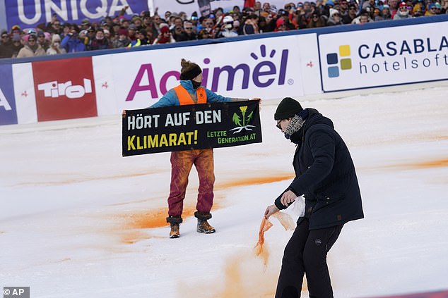 A Last Generation demonstrator sprays paint in the finish area of ​​an alpine ski, men's World Cup slalom in Gurgl, Austria, Saturday, Nov. 18, 2023