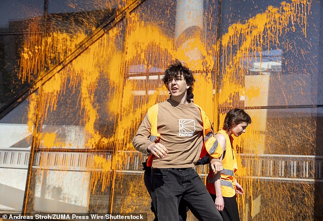 Climate activists from 'Last Generation Austria' spray the Vienna University of Economics and Business orange with a fire extinguisher