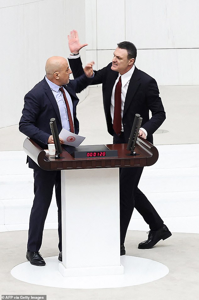 In extraordinary scenes, fists were exchanged between lawmakers in the Turkish parliament today after opposition MP Ahmet Sik (left) called the ruling party a 