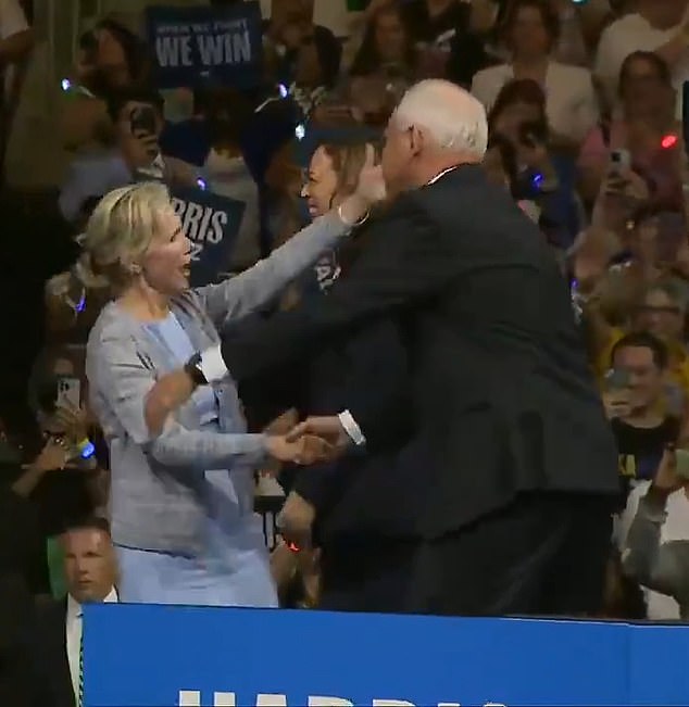 Kamala Harris's newly named running mate Tim Walz greets his wife Gwen onstage before an adoring audience... and welcomes her with a firm handshake