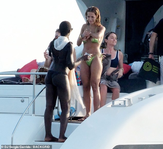 Jodie looked amazing as she shared a laugh with Rita, teaming her tiny bikini with a white headscarf and stylish sunglasses