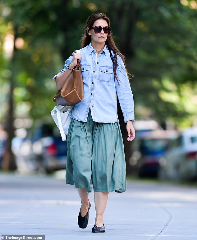 Katie Holmes looked chic as she walked solo through New York City on Friday. The Batman Begins veteran wore a light blue denim chambray shirt