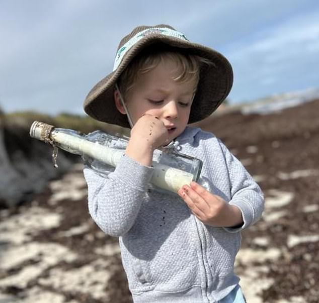 Four-year-old Leo (pictured) found a bottle with a rolled up note inside while searching for treasure on Tuesday