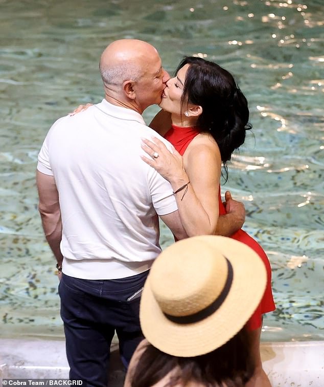 Lauren Sanchez dazzled in a bright red, backless halter dress as she kissed her fiancé, Jeff Bezos