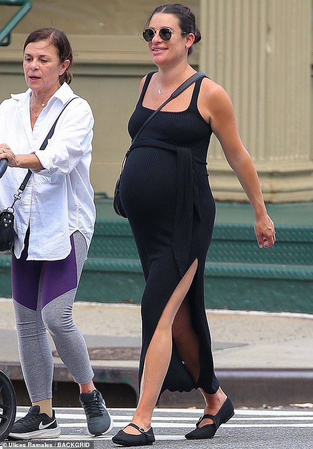 Lea Michele draped her blossoming baby bump in a flowing black dress as she stepped out with her mother Edith Sarfati in New York City this week