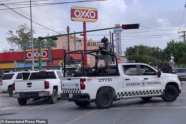 Mexican soldiers stand guard outside an Oxxo supermarket near the Tamaulipas Chamber of Commerce, where president Julio Cesar Almanza was killed, in Matamoros, Mexico, Tuesday, July 30, 2024. (AP Photo/Veronica Cisneros)