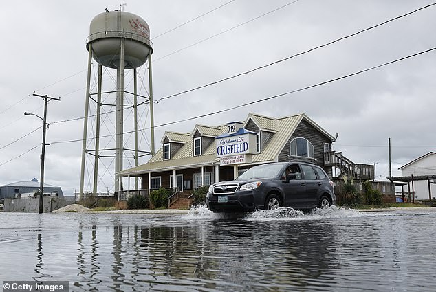 A motorist navigates a flooded intersection after heavy rains in Crisfield, Maryland, one of the states most at risk from coastal flooding.