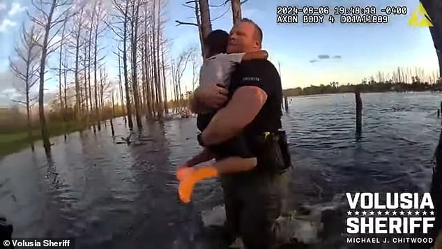 The photo shows Officer Wes Brough rescuing the boy from the pond