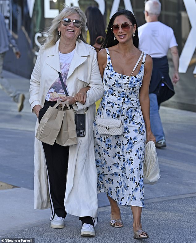 Nicole Scherzinger, 46, soaked up the sunshine in a white and blue floral dress on Sunday as she went out with a friend in Manchester