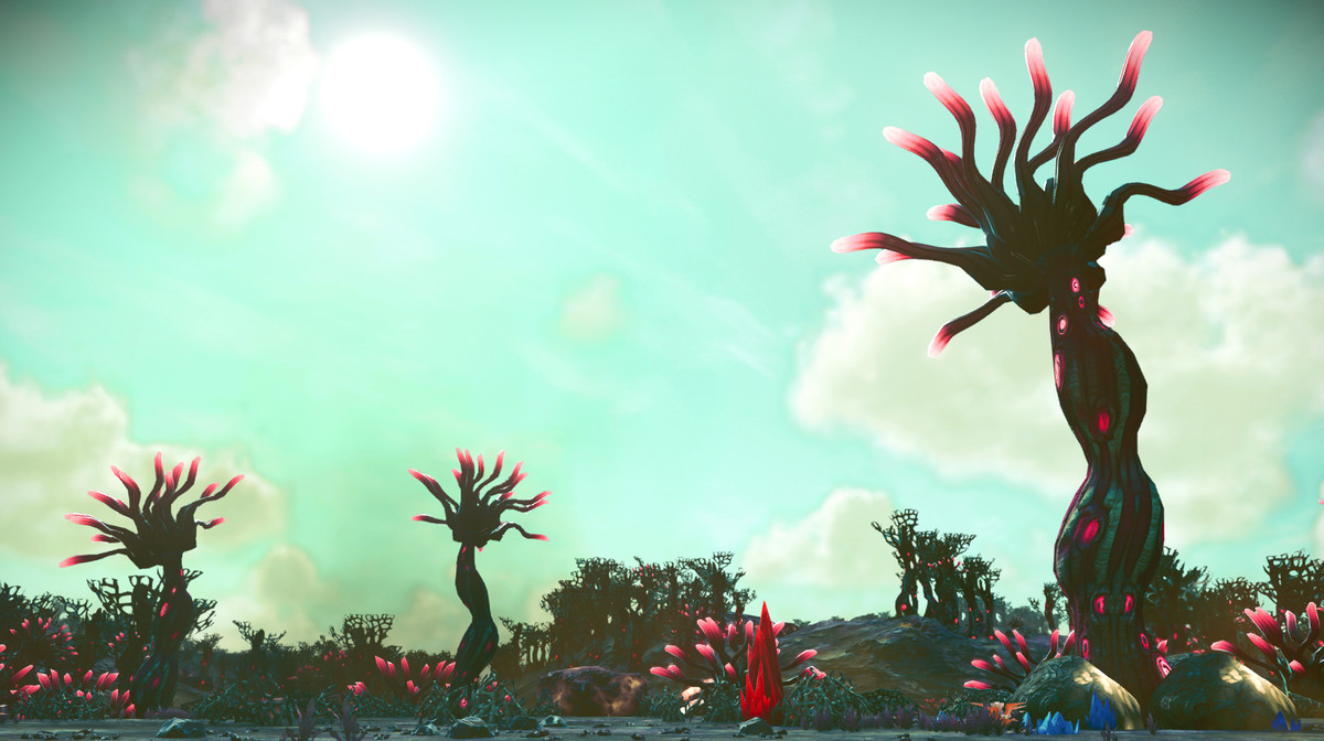 Three plants on a planet in No Man's Sky, with sparse vegetation topped with pink orbs, against a light cyan sky.