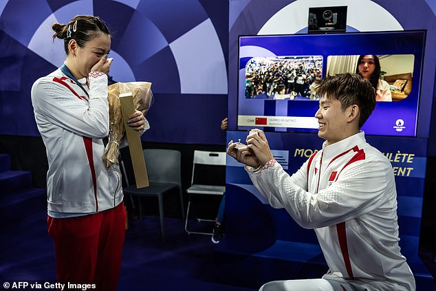 A Chinese badminton player who proposed to his girlfriend after she won gold at the Paris Olympics has been criticised by fans online for 'making the moment about him'