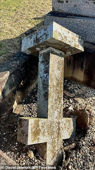 A fallen cross on a grave