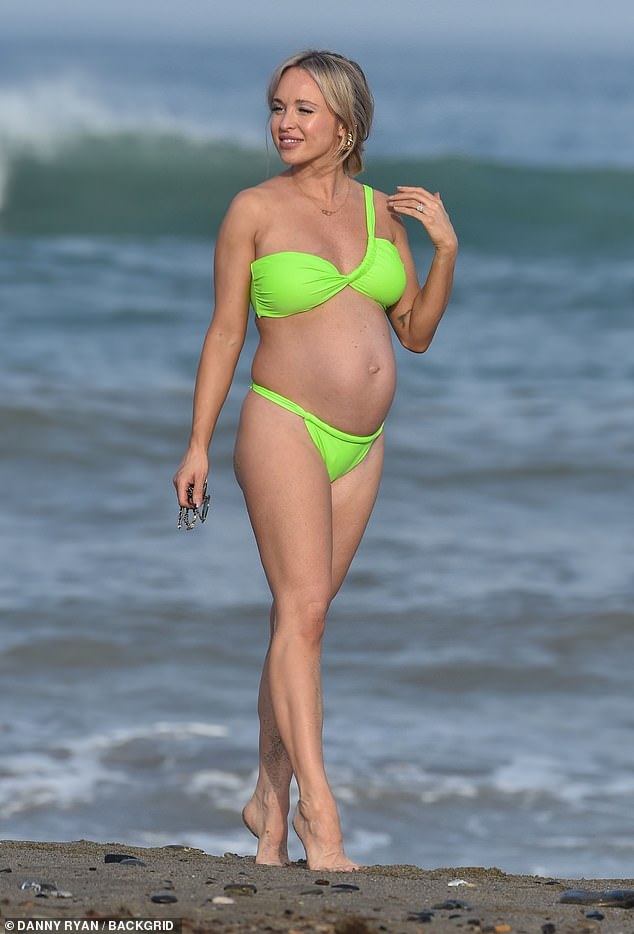 Pregnant Jorgie Porter looked sensational as she showed off her baby bump in a tiny green bikini while soaking up the sun in Spain on Saturday