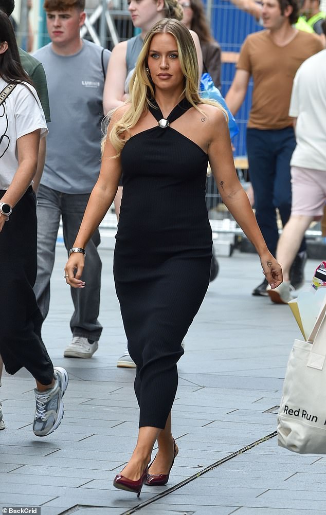 Lottie Tomlinsonc, 25, showed off her growing baby bump in a tight black halter dress as she headed to her book launch at Waterstones in Liverpool on Friday