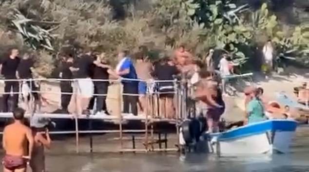 Chaotic footage captured the moment a man was thrown from a pier into a boat during a brawl on a pier in Italy