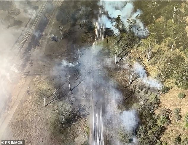 The head-on collision on the Bruce Highway in central Queensland killed a van driver and caused ammonium nitrate to leak, causing a fiery explosion and leaving a huge crater (pictured)