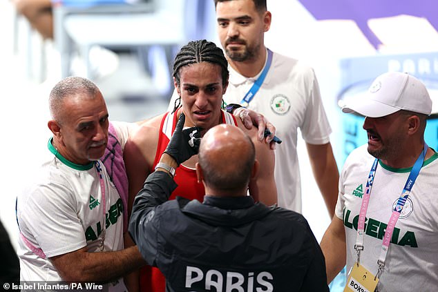 Imane Khelif, 25, burst into tears as she was hugged by her team today after her victory in the women's boxing quarter-finals