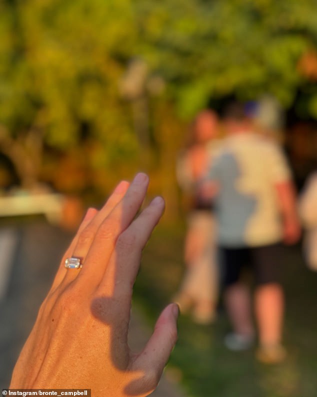 The four-time Olympic gold medalist shared a photo showing off the stunning east-west emerald-cut diamond on a gold band