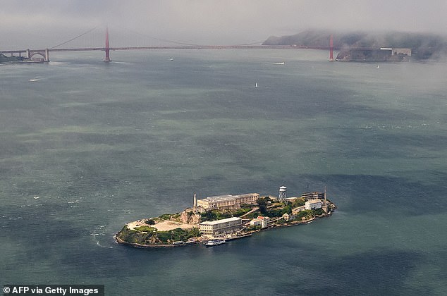 An aerial view shows Alcatraz Federal Penitentiary or 'The Rock' in front of the Golden Gate Bridge in San Francisco. Alcatraz Island is located 1.25 miles (2.01 km) off the coast of San Francisco