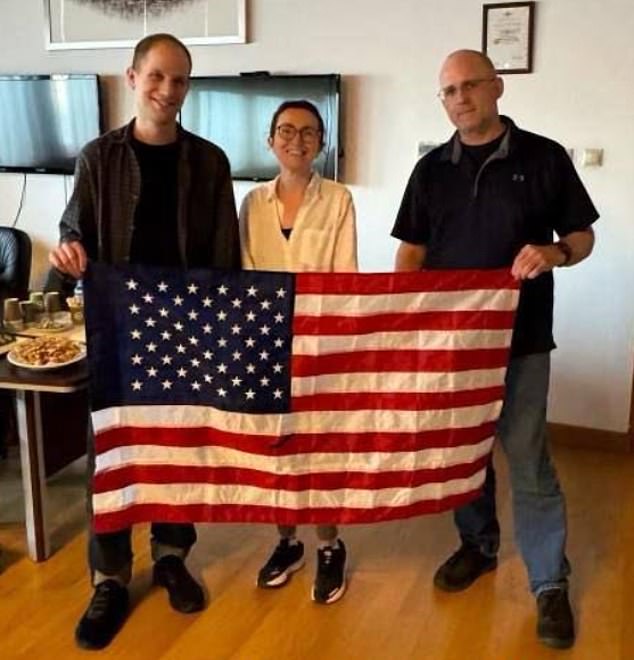 The trio posed with an American flag with returning citizen Alsu Kurmasheva (center), who was also released on Thursday.