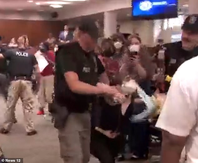 Video from New York's Nassau County Legislature captured the shocking moment a mask advocate had to be dragged out of the meeting after lawmakers voted to ban face masks in public spaces