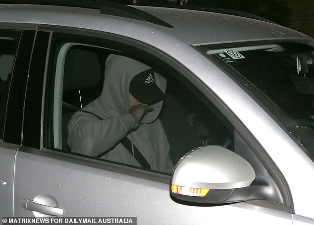 Another man, disguised as Amon, left the police station from the front wearing a gray hoodie and a similar baseball cap (pictured)