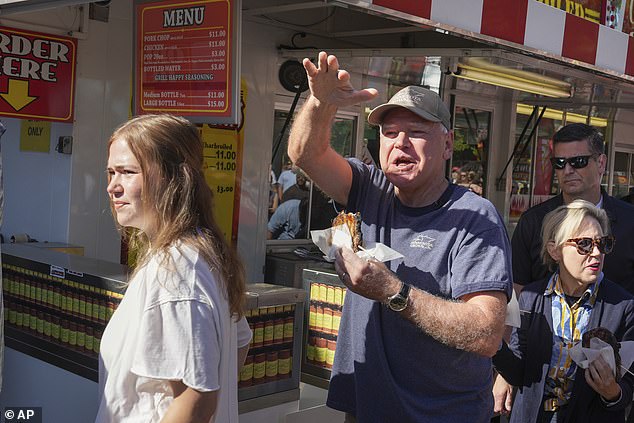 Walz is seen eating some street food at the event, along with his daughter Hope (left) and wife Gwen (right). He did not answer questions about the policy during their brief visit.