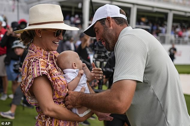 Scottie Scheffler holds his son Bennett Ezra Scheffler as his wife Meredith Scudder looks on