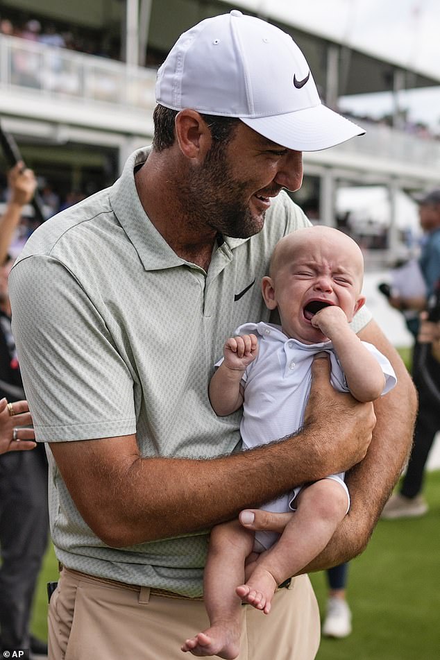 Scottie Scheffler holds his son Bennett Ezra Scheffler on the 18th green