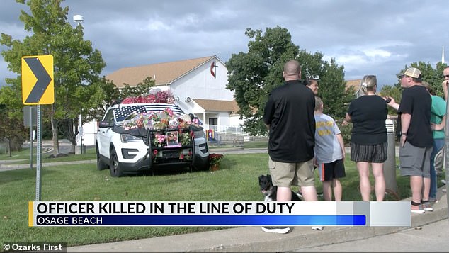 Community members gathered at the police station last weekend to place pink flowers on a patrol car in memory of Carson