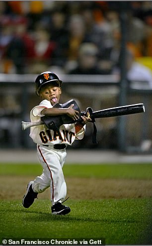 Darren Baker, 3, son of San Francisco Giants manager Dusty Baker, runs off the field after picking up Barry Bonds' bat and elbow pad during Game 4 of the National League Championship Series at Pac Bell Park in San Francisco, Calif., Sunday, October 13, 2002