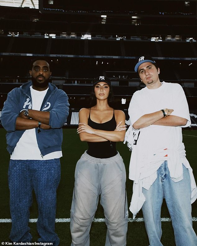 In another snap, Kardashian stood on the field alongside her friends, Simon Gebrelul and Savas Oguz, as they all posed with their arms crossed. She looked effortlessly stylish as she wore a low-cut black bodysuit with baggy gray sweatpants and a New York Yankees baseball cap