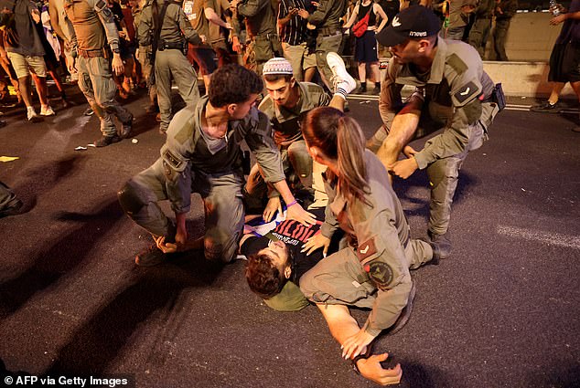 Israeli police officers arrest a protester during clashes after an anti-government demonstration calling for the release of Israelis held hostage by Palestinian militants in Gaza since October