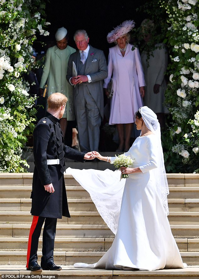 Prince Harry and Meghan look back at their family on their wedding day as Doria, Charles and Camilla leave the chapel