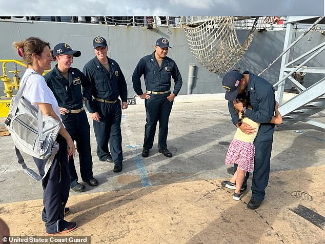 A 7-year-old girl hugs a Navy sailor at Joint Base Pearl Harbor-Hickam in Honolulu on Aug. 28, 2024. The Navy ship launched a small boat crew to rescue the girl, her mother, their cat and turtle after their sailboat was battered by weather in the path of an approaching hurricane