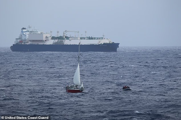 The crew of a small boat sails away from the French-flagged sailing ship Albroc after recovering the mother and daughter during rescue operations in the Pacific Ocean on August 26, 2024